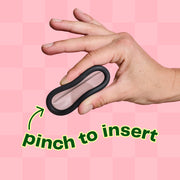 A hand is shown pinking the Viv Disc in the middle to form the shape of the number 8. To insert the Viv DIsc, pinch it in the middle like this, and guide the folded egdge into your body.